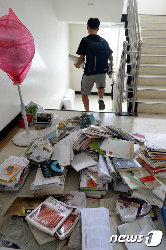 (청주=뉴스1) 장수영 기자 = 17일 충북 청주시 서원구 운호고에서 학생들이 물에 젖은 책을 뒤로 한 채 단축수업을 마치고 있다.충북도교육청은 침수피해를 입은 5개 학교에서 휴교 …