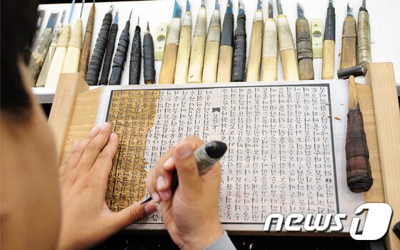본문 이미지 - 6일 전북 전주시 국립무형유산원에서 열린 '전주 완판본체 선포식'에 참가한 전주완판본문화관 담당자가 부대행사인 완판본 전통 판각 시연을 하고 있다.2017.7.6/뉴스1 ⓒ News1 문요한 기자