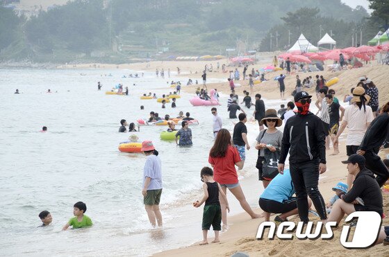 본문 이미지 - 7일 개장한 강원도 속초해수욕장에서 피서객들이 흐린 날씨에도 물놀이를 하며 즐거운 오후를 보내고 있다. 이날 강릉 경포, 양양 낙산해수욕장 등이 함께 개장해 본격적인 운영에 들어갔다. 2017.7.7/뉴스1 ⓒ News1 고재교 기자
