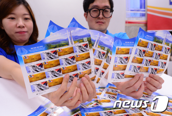 (서울=뉴스1) 허경 기자 = 1일 서울 광화문우체국에서 직원들이 '독립기념관 개관 30주년'을 기념해 발행된 우표 2종을 선보이고 있다.이번 기념우표는‘흑성산에서 바라본 독립기념 …
