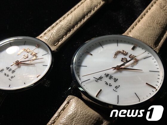 본문 이미지 - 청와대가 문재인 대통령의 이름을 새겨 넣은 기념품용 손목시계를 제작해 10일 춘추관에서 공개했다. 대통령을 상징하는 봉황무늬와 문 대통령의 사인이 들어가있다. 2017.8.10/뉴스1 ⓒ News1 김명섭 기자