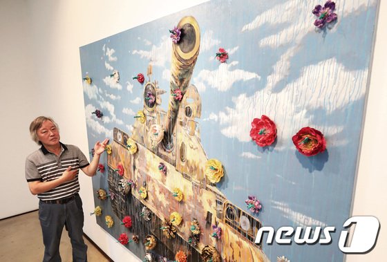 본문 이미지 - 민중미술 작가 송창 화백(65)이 16일 서울 종로구 학고재 갤러리에서 막을 올린 '꽃그늘'(Flower-Shade)' 전에서 작품을 배경으로 포즈를 취하고 있다. 2017.8.16/뉴스1 ⓒ News1 오대일 기자