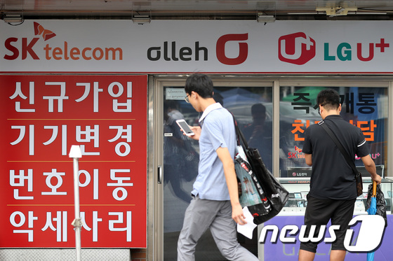 서울 용산구의 한 휴대폰 판매업소 앞을 시민들이 지나고 있다. © News1 임세영 기자