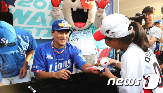 (수원=뉴스1) 오장환 기자 = 삼성 라이온즈 이승엽이 18일 오후 경기도 수원시 장안구 kt위즈파크에서 열린 은퇴 기념 팬사인회에서 꼬마 야구 팬에게 사인을 해주고 있다. 201 …