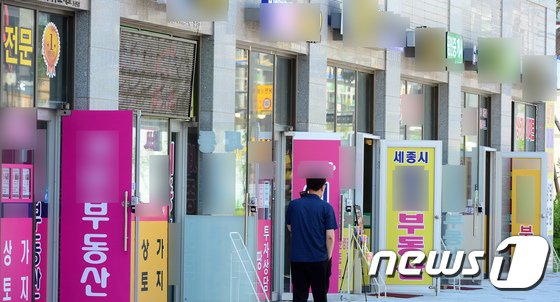 본문 이미지 - 세종시의 한 아파트 단지 상가에 위치한 공인중개소에 시민들이 지나가고 있다. /뉴스1 ⓒ News1 장수영 기자