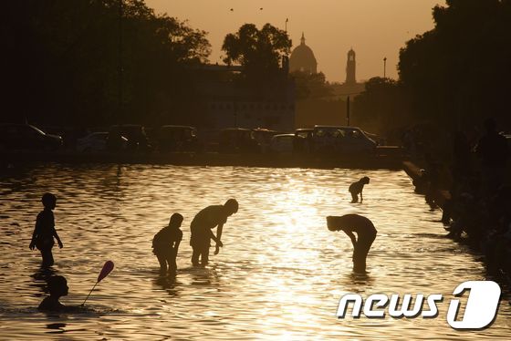 더운 여름날 인도 뉴델리의 강에서 사람들이 목욕하고 있다. © AFP=뉴스1