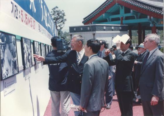 본문 이미지 - 1997년 5월17일 망월동 5.18국립묘지 뒷쪽에서 5.18 당시 사진을 가리키고 있는 힌츠페터. (이재의 제공) ⓒNews1