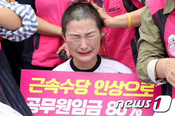 (서울=뉴스1) 임세영 기자 = 19일 오전 서울 종로구 정부서울청사 앞에서 열린 근속수당 인상 쟁취 학교비정규직 집단 삭발 기자회견에서 전국학교비정규직노동조합원이 교육부장관 및 …