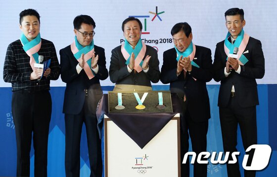 본문 이미지 - 21일 서울 동대문구 동대문디자인플라자에서 열린 2018 평창 동계올림픽대회 메달 공개 행사에서 도종환 문화체육관광부 장관을 비롯한 내빈들이 메달을 공개하고 있다. 왼쪽부터 홍보대사 정찬우, 송석두 강원도 행정부지사, 도종환 문체부장관, 이희범 조직위원장, 홍보대사 션. 평창 동계올림픽 메달리스트들에게 수여될 메달은 우리 민족의 상징인 한글을 모티브로 세계 각국 선수의 열정과 노력을 담아 제작됐다. 서울과 뉴욕에서 동시에 발표된 평창 동계올림픽 메달은 대회 상징물, 동계종목 피규어 등과 함께 오는 24일까지 동대문디자인플라자 어울림마당에 전시돼 일반 국민들에게 공개된다. 2017.9.21/뉴스1 ⓒ News1 오대일 기자
