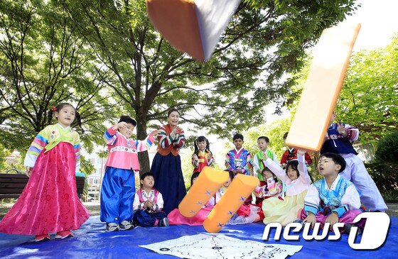 본문 이미지 - 추석 연휴 시작을 이틀 앞둔 28일 오전 광주 북구 중흥어린이집 앞 효죽공에서 어린이들이 한복을 입고 전통놀이인 윷놀이를 하고 있다. (광주 북구 제공) 2017.9.28/뉴스1 ⓒ News1