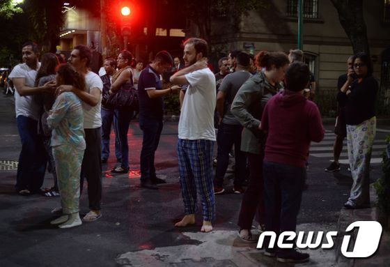 본문 이미지 - 8일(현지시간) 멕시코 수도 멕시코시티의 한 거리에 시민들이 잠옷을 입은 채 대피해있다. ⓒ AFP=뉴스1