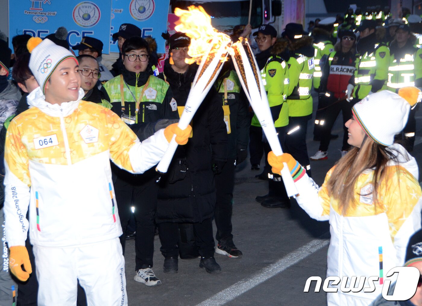 본문 이미지 - 2018 평창올림픽 개막을 11일 앞둔 29일 오후 강원도청 인근에서 전 피겨선수인 일본의 안도미키(오른쪽)가 장근석에게 성화 불꽃을 이어주고 있다. 2018.1.29/뉴스1 ⓒ News1 하중천 기자