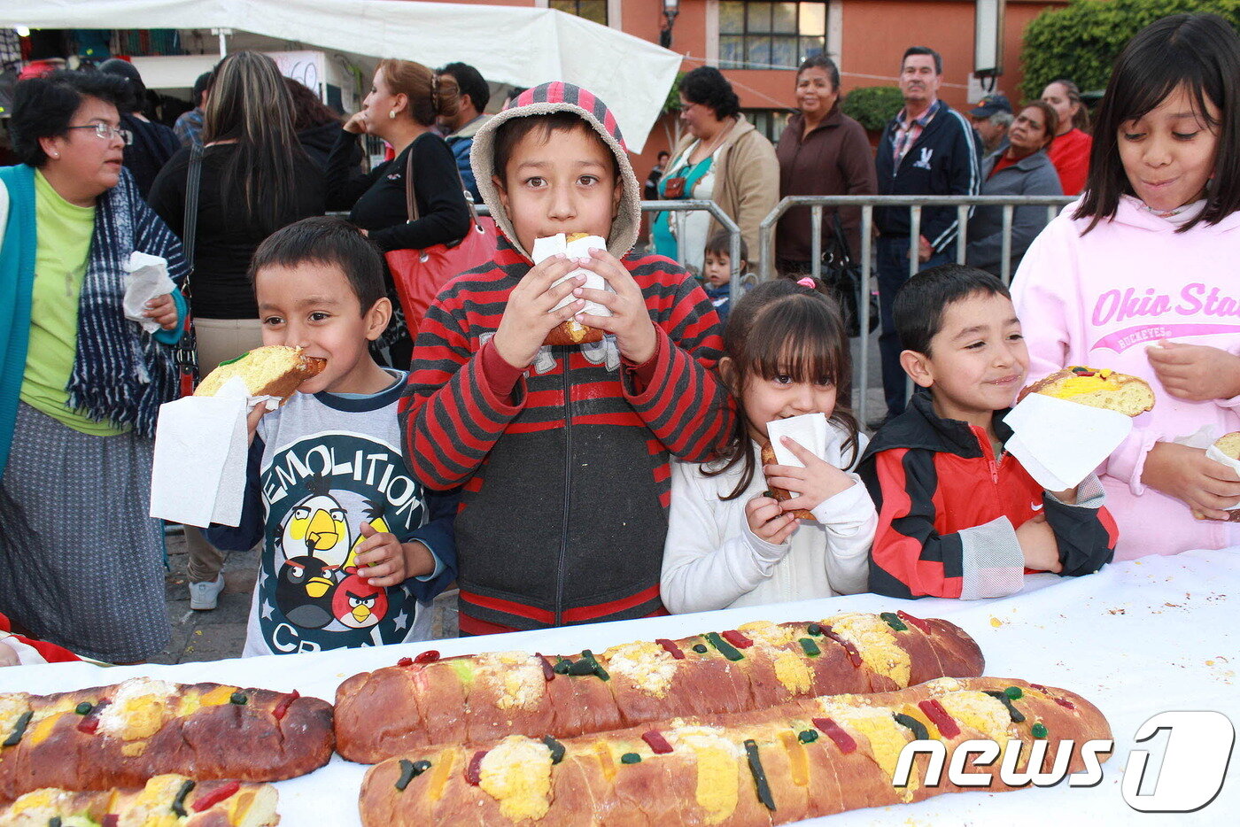 본문 이미지 - 동방박사의 날에 길이 1500m로 만들어진 진 '로스 카 데 레예스'를 나눠 먹는 아이들의 모습. 멕시코관광청 제공.ⓒ News1