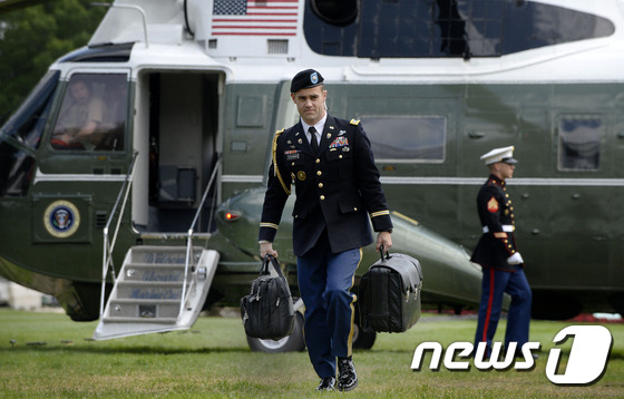 오바마 전 미국 대통령 전용기 앞에서 미군 장교가 풋볼을 들고 이동 중이다. © AFP=뉴스1