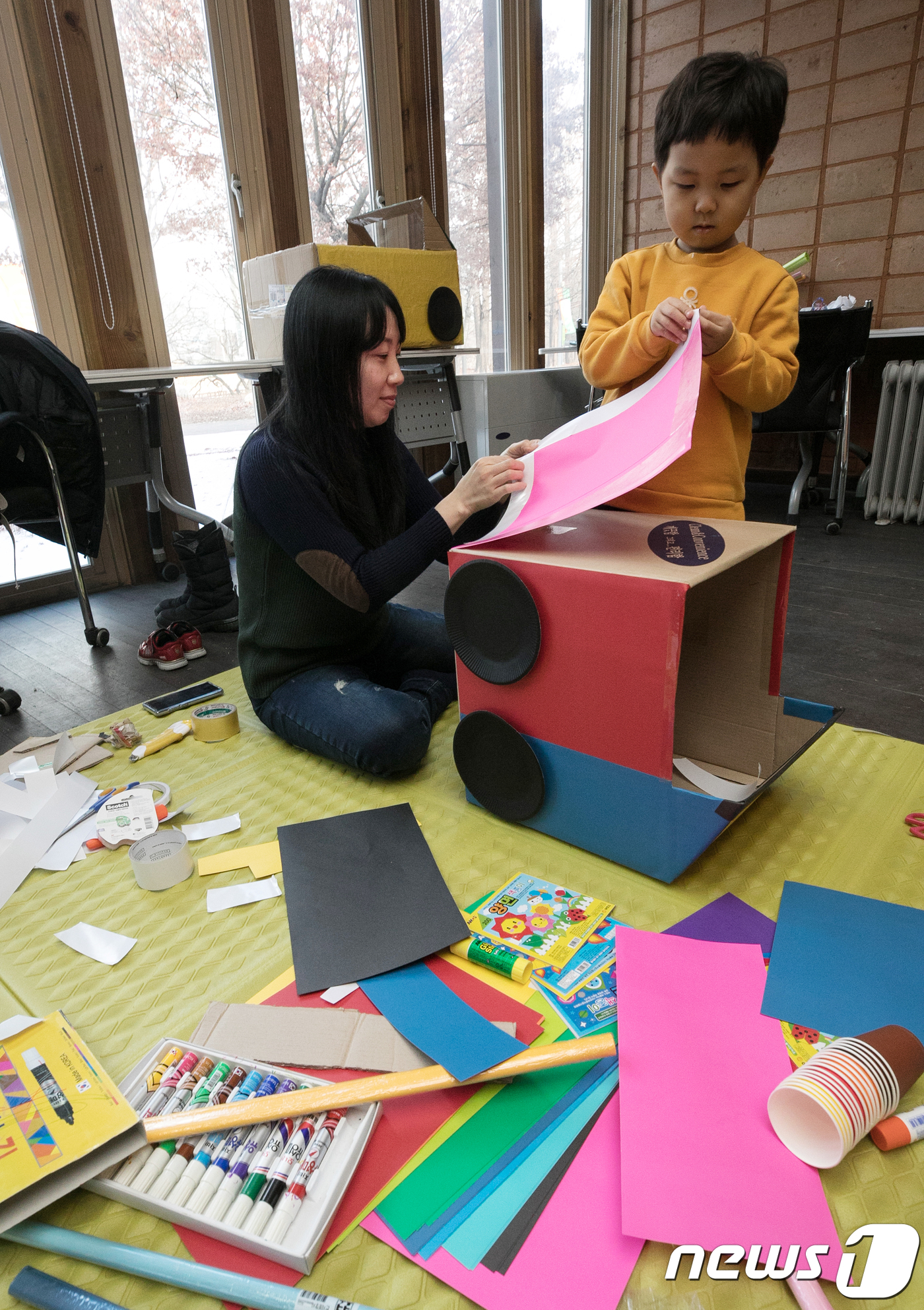 (서울=뉴스1) 이승배 기자 = 9일 오후 서울 성동구 서울숲 생태학습장에서 열린 서울숲 겨울방학 프로그램 '박스 자동차 극장'에 참가한 어린이가 엄마와 함께 종이와 상자를 이용해 …