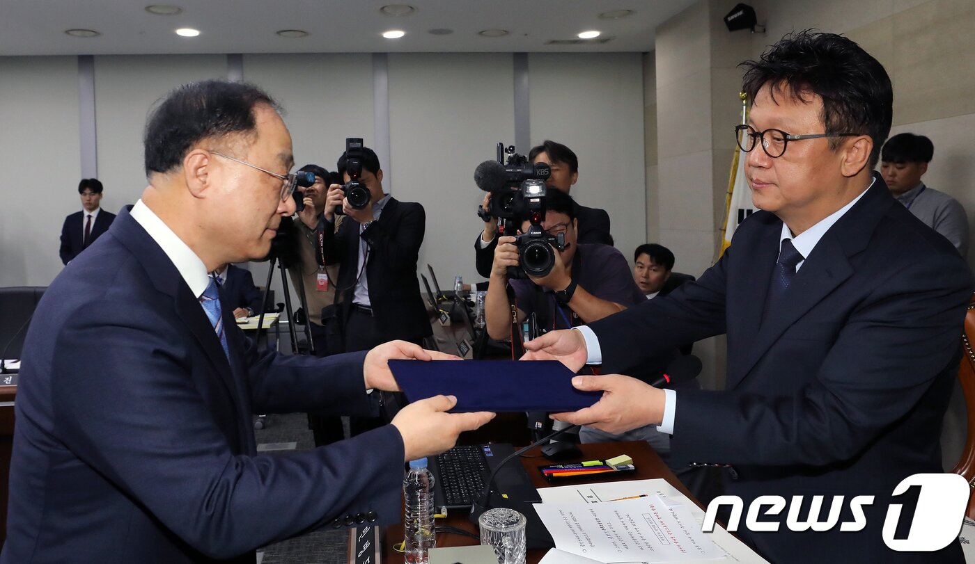 본문 이미지 - 홍남기 국무조정실장이 10일 정부세종청사에서 열린 국회 정무위원회의 국무조정실·국무총리비서실·가습기살균제사건과 4·16세월호참사 특별사위원회에 대한 국정감사에서 민병두 위원장에게 선서문을 전달하고 있다. 2018.10.10/뉴스1 ⓒ News1 장수영 기자