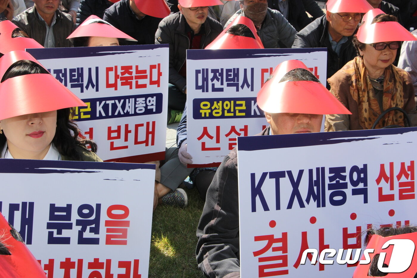 본문 이미지 - 지난 12일 오전 세종시 보람동 세종시청 앞에서 열린 'KTX세종역 신설 중단촉구 규탄대회‘ 참가자들이 손팻말을 들고 구호를 외치고 있다. 2018.10.12./뉴스1 ⓒ News1 이길표 기자 
