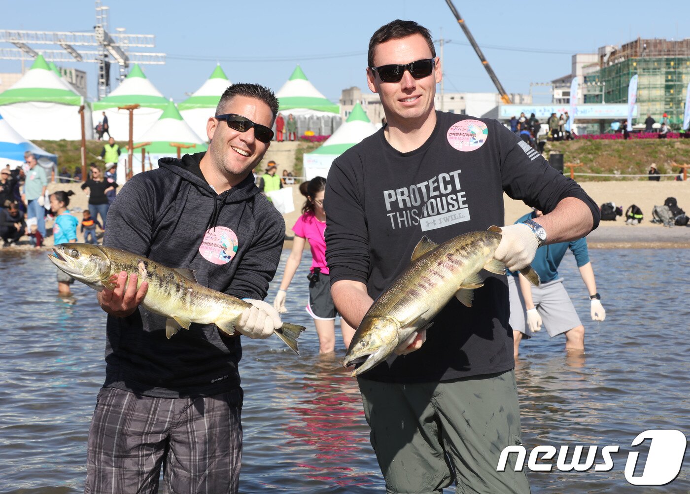 본문 이미지 - 강원도 양양군 남대천 일원에서 열린 ‘2018양양연어축제’에서 연어맨손잡기 체험에 참가한 외국인 관광객들이 직접 잡은 연어를 들어 보이고 있다.&#40;자료사진&#41; &#40;양양군 제공&#41; 2018.10.21/뉴스1 ⓒ News1 고재교 기자