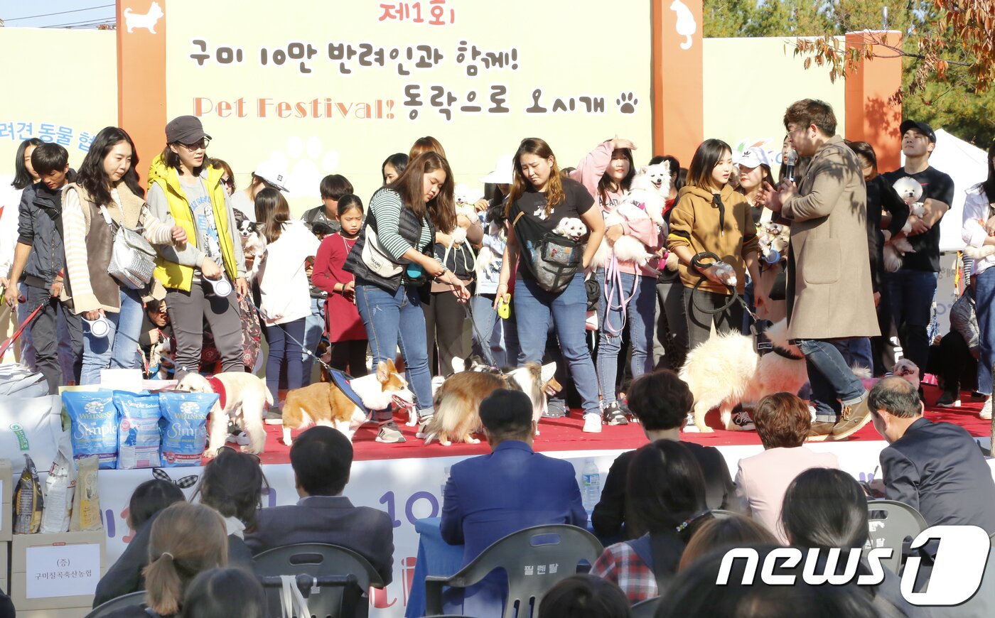 본문 이미지 - 21일 경북 구미시 동락공원 반려동물 놀이터서 열린 '제1회 구미 펫 페스티벌'에 참가한 반려인들이 애완견을 품에 안고 '예쁜 애완견 선발대회' 심사를 받고 있다. 구미시는 지난달 동락공원에 2억원을 들여 4천300㎡ 공간에 경북도에서는 처음으로 반려견 놀이터를 조성해 반려견들이 목줄 없이 뛰놀 수 있도록 했다.2018.10.21/뉴스1 ⓒ News1 정우용 기자