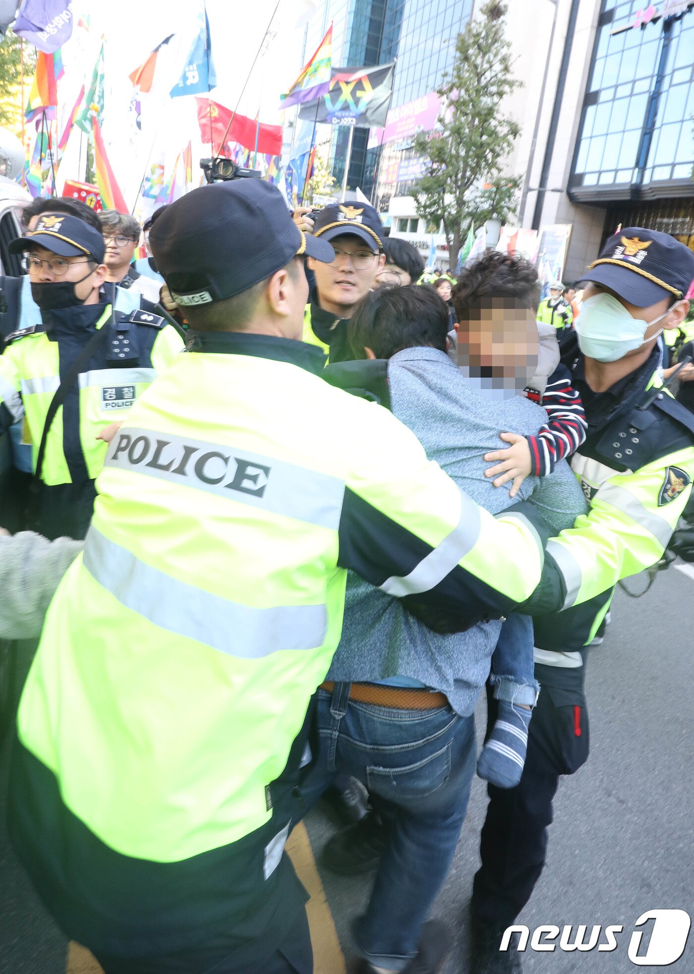 본문 이미지 - 21일 오후 광주 동구 5·18민주광장에서 열린 제1회 광주퀴어문화축제에서 퀴어문화축제를 반대 하는 한 시민이 아이를 안고 퀴어문화축제 참석자들의 행진을 온몸으로 가로 막고 있다.2018.10.21/뉴스1 ⓒ News1 남성진 기자