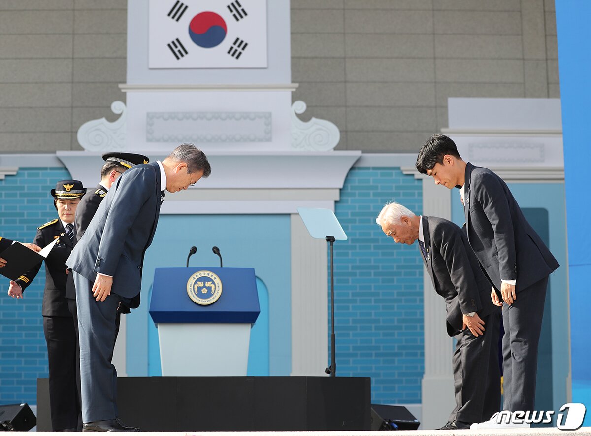 본문 이미지 - 문재인 전 대통령이 지난 2018년 10월 25일 서울 용산구 백범김구기념관에서 열린 제73주년 경찰의 날 기념식에서 올해의 경찰영웅인 고(故) 문형순 서장의 대리수상자인 강순주 씨, 고(故) 김학재 경사의 대리수상자인 김현기 씨에게 경찰영웅패 수여에 앞서 인사하고 있다. (청와대 제공) 2018.10.25/뉴스1