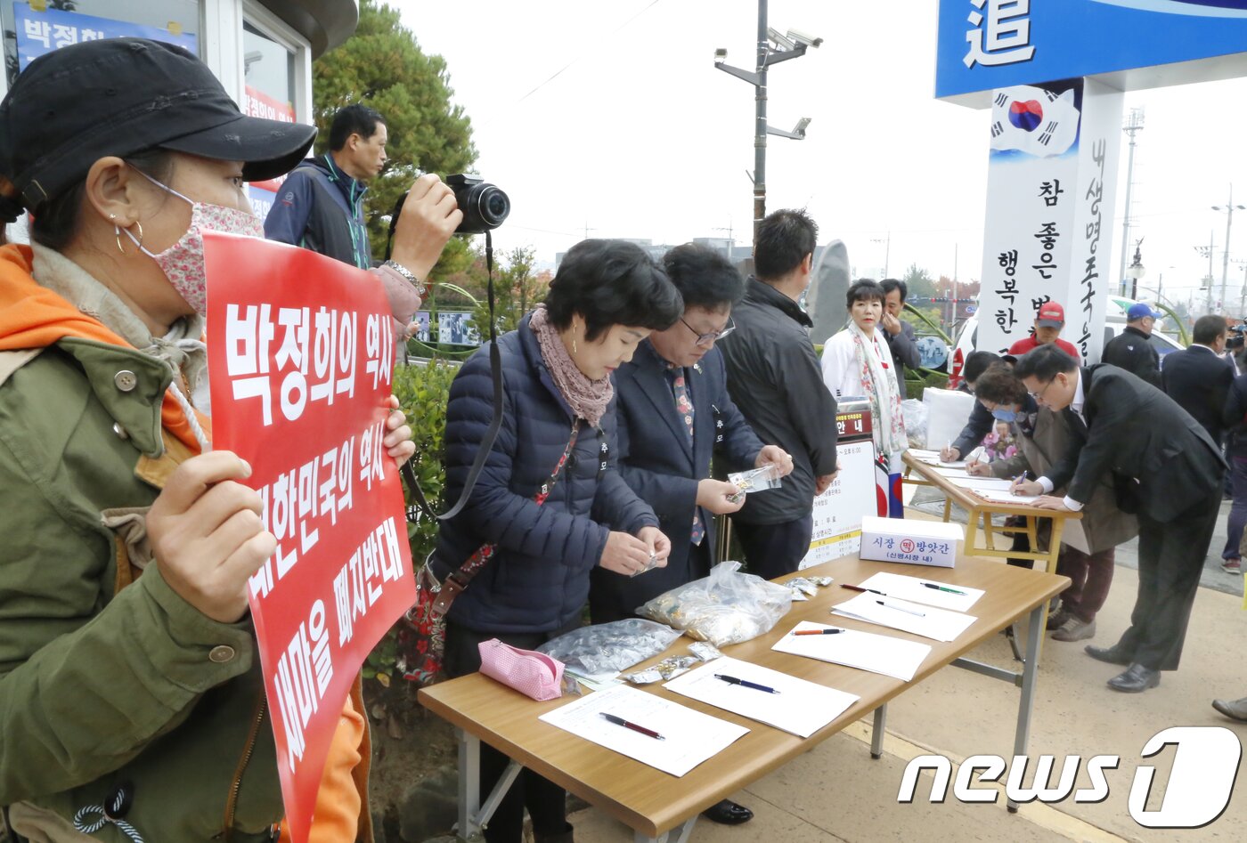 본문 이미지 - 26일 경북 구미시 상모동 박정희 전 대통령 생가에서 열린 '박정희 대통령 제39기 추도식'장 앞에서 박정희 생가보존회에서 참석자들을 대상으로 '박정희대통령 역사지우기 반대 서명'을 받고 있다.2018.10.26/뉴스1 ⓒ News1 정우용 기자
