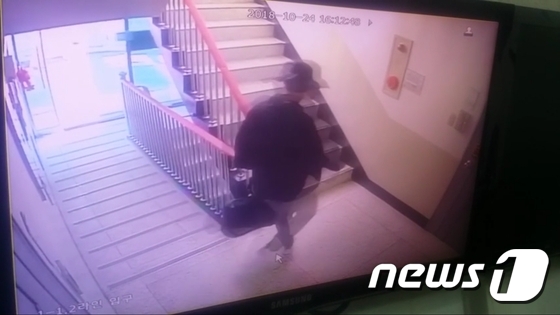 용의자가 범행도구를 들고 아파트 계단을 올라가는 모습.(부산지방경찰청 제공)© News1