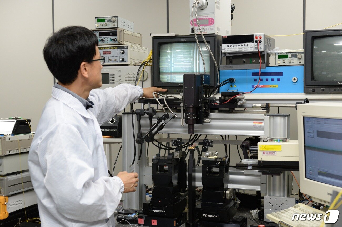 본문 이미지 - ETRI 김진태 박사가 이번에 개발된 광소자의 형상을 현미경으로 관찰하고 있다.ⓒ News1