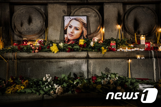 지난 8일 시신으로 발견된 불가리아의 여성 기자인 빅토리아 마리노바의 사진 앞에 추모객들이 꽃과 촛불을 바쳤다. © News1
