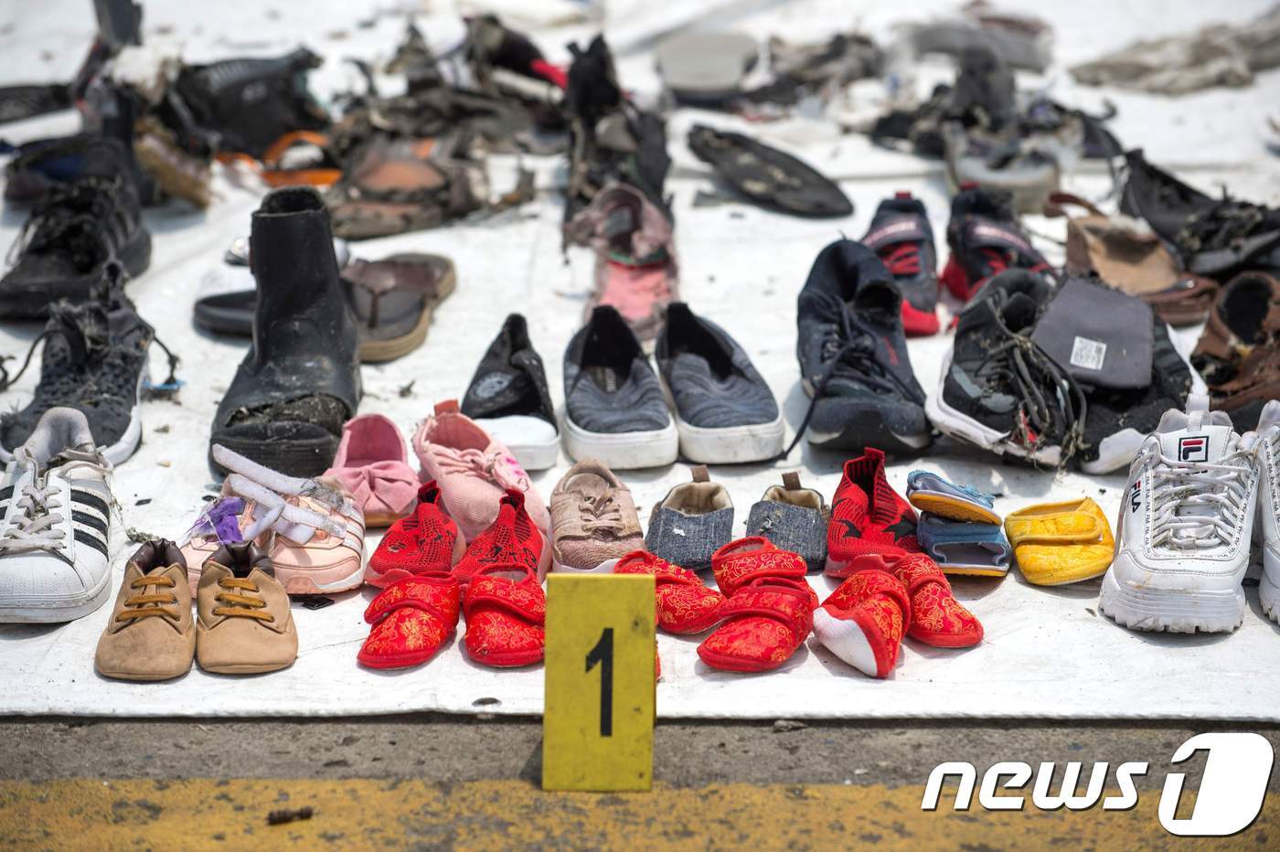 본문 이미지 - 인도네시아 자카르타 탄중 프리옥 항에 지난달 29일 추락한 라이온에어 여객기 승객들의 것으로 보이는 신발들이 회수돼 있다.ⓒ AFP=뉴스1