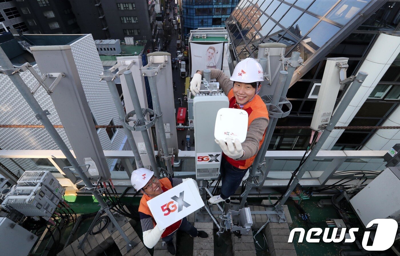 본문 이미지 - SK 텔레콤 직원들이 5G 전파 송출을 보름여 앞둔 14일 오전 서울 중구 명동의 한 빌딩 옥상에서 5G 기지국을 설치하고 있다.  2018.11.14/뉴스1 ⓒ News1 안은나 기자