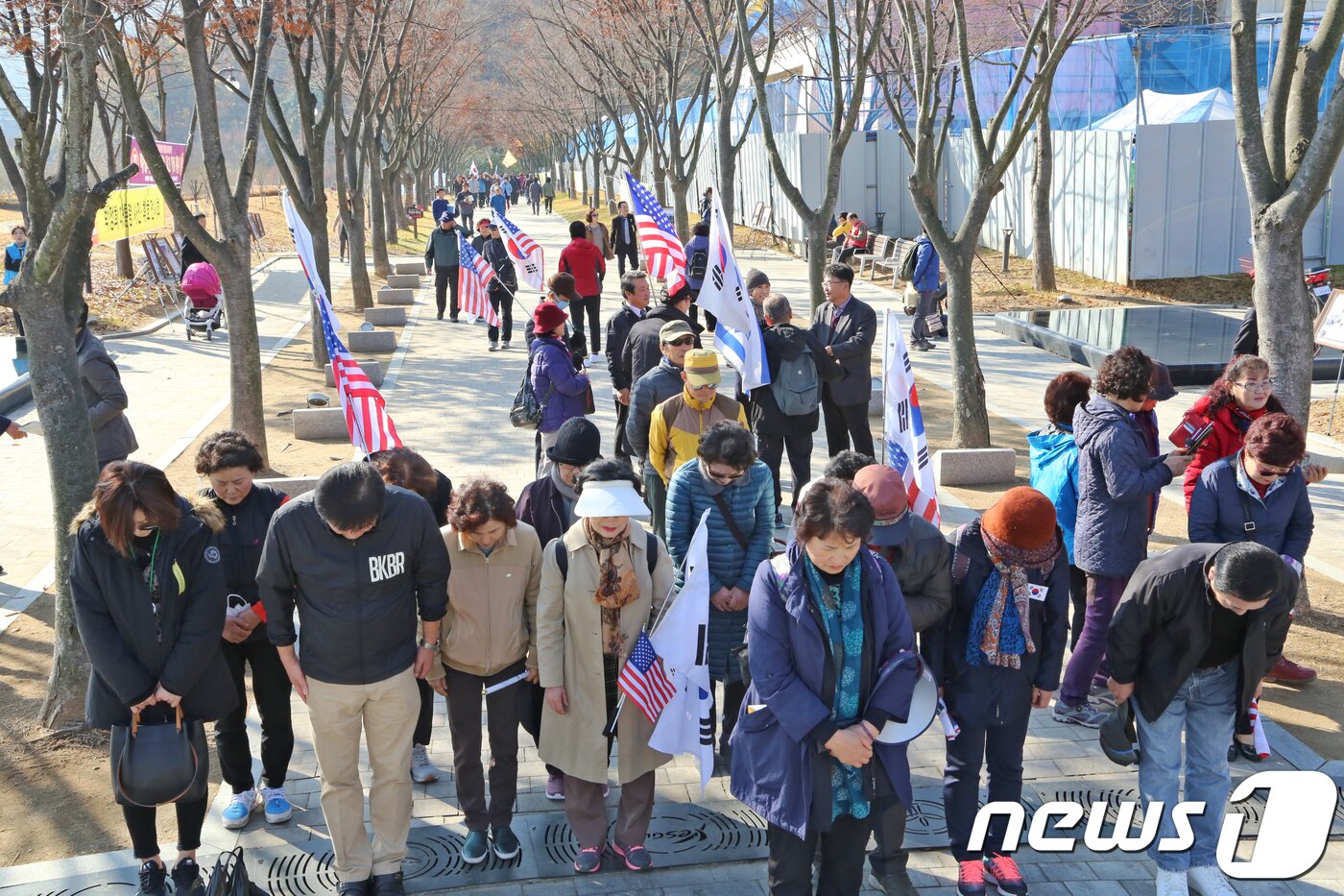 본문 이미지 - 14일 경북 구미시 故박정희 대통령 생가 에서 열린 '박정희 대통령 탄생 101돌 기념식'에 참석한 태극기를 든 시민들이 박정희 동상앞에서 묵념을 올리고 있다.2018.11.14/뉴스1 ⓒ News1 정우용 기자