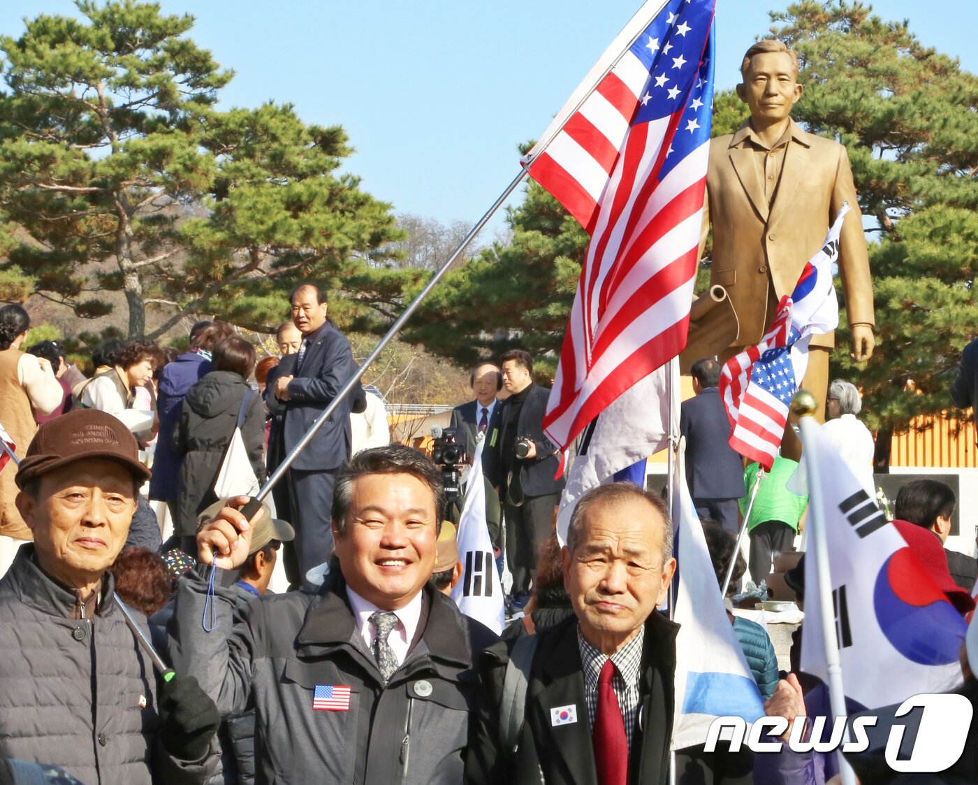 본문 이미지 - 14일 경북 구미시 박정희 대통령 생가 에서 열린 '박정희 대통령 탄생 101돌 기념식'에 참석한 태극기를 든 시민들이 박정희 동상앞에서 묵념을 올리고 있다..2018.11.14/뉴스1 ⓒ News1 정우용 기자