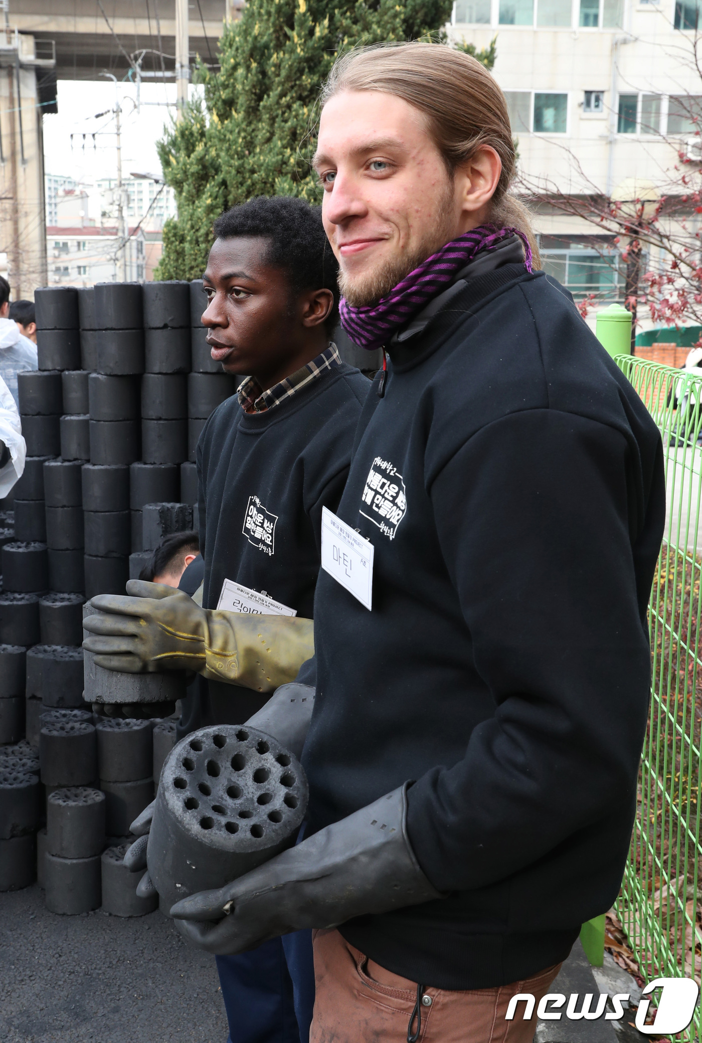 (인천=뉴스1) 정진욱 기자 = 인하대 외국인 교환학생이 23일 오후 인천시 미추홀구 학익동에서 연탄을 나르고 있다.이날 학생 및 한진그룹 관계자들은 40가구의 어려운 이웃들에게 …