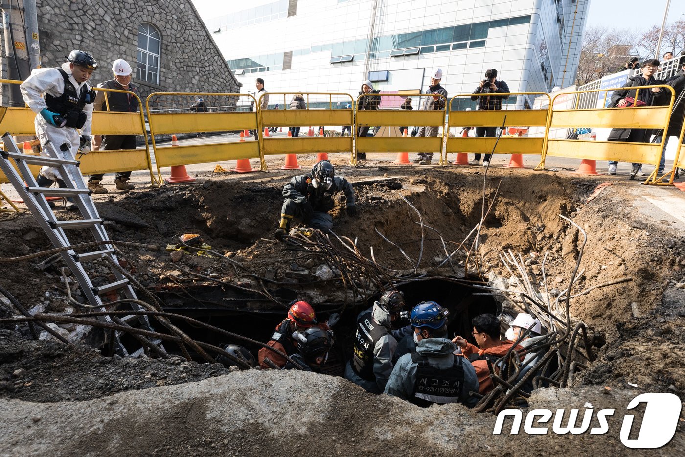 경찰과 소방대원들이 25일 오전 서울 서대문구 충정로 KT아현국사 앞 공동구 화재현장에서 전날 발생한 화재 원인을 조사하기 현장 감식을 하고 있다. 소방대원들은 전날 화재 현장 접근을 위해 공동구 화재현장에 굴착기로 땅을 파고 연기를 빼냈다.2018.11.25/뉴스1 ⓒ News1 유승관 기자