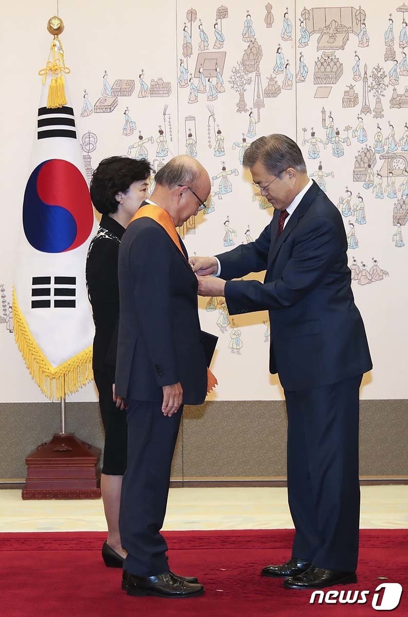 본문 이미지 - 문재인 대통령이 7일 오전 청와대에서 퇴임한 안창호 전 헌법재판소 재판관에게 청조 근정훈장을 수여한 뒤 대수를 어깨에 걸어주고 있다. (청와대 제공) 2018.11.7/뉴스1