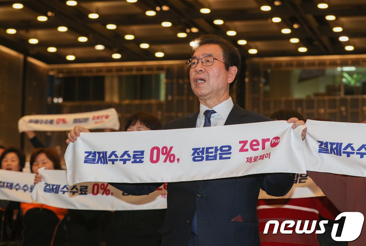 본문 이미지 - 박원순 서울시장이 20일 서울 중구 대한상공회의소에서 열린 '제로페이 이용확산 결의대회 및 결제시연'에서 제로페이 이용을 촉구하며 손피켓을 들고 구호를 외치고 있다. 내년 3월 이후 정식서비스되는 '제로페이'는 결제 카운터에 비치된 QR코드를 스마트폰앱으로 인식하면 내 계좌에서 판매자 계좌로 금액이 이체되는 모바일 직거래 시스템이다. 소비자는 40% 소득공제 혜택 등을 받을 수 있으며 소상공인의 경우 제로페이로 결제시 수수료가 0%가 된다. 2018.12.20/뉴스1 ⓒ News1 성동훈 기자