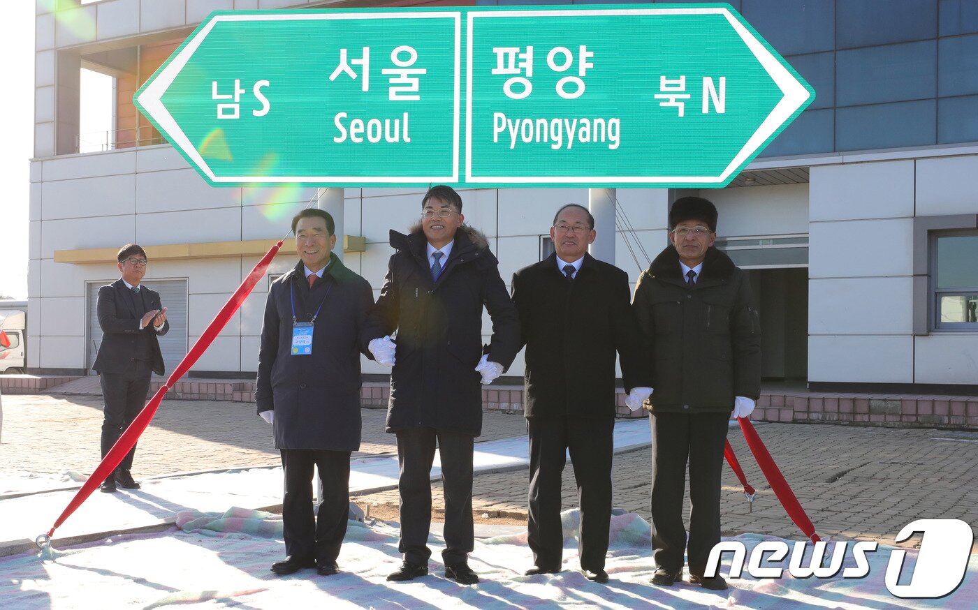 본문 이미지 - 26일 오전 북한 개성시 판문역에서 열린 남북 동서해선 철도, 도로 연결 및 현대화 착공식에 참석한 이강래(왼쪽부터) 한국도로공사 사장, 천해성 통일부 차관, 북한 박호영 국토환경보호성 부상 등이 서울-평양 표지판 제막식을 하고 있다. 2018.12.26/뉴스1 ⓒ News1 사진공동취재단