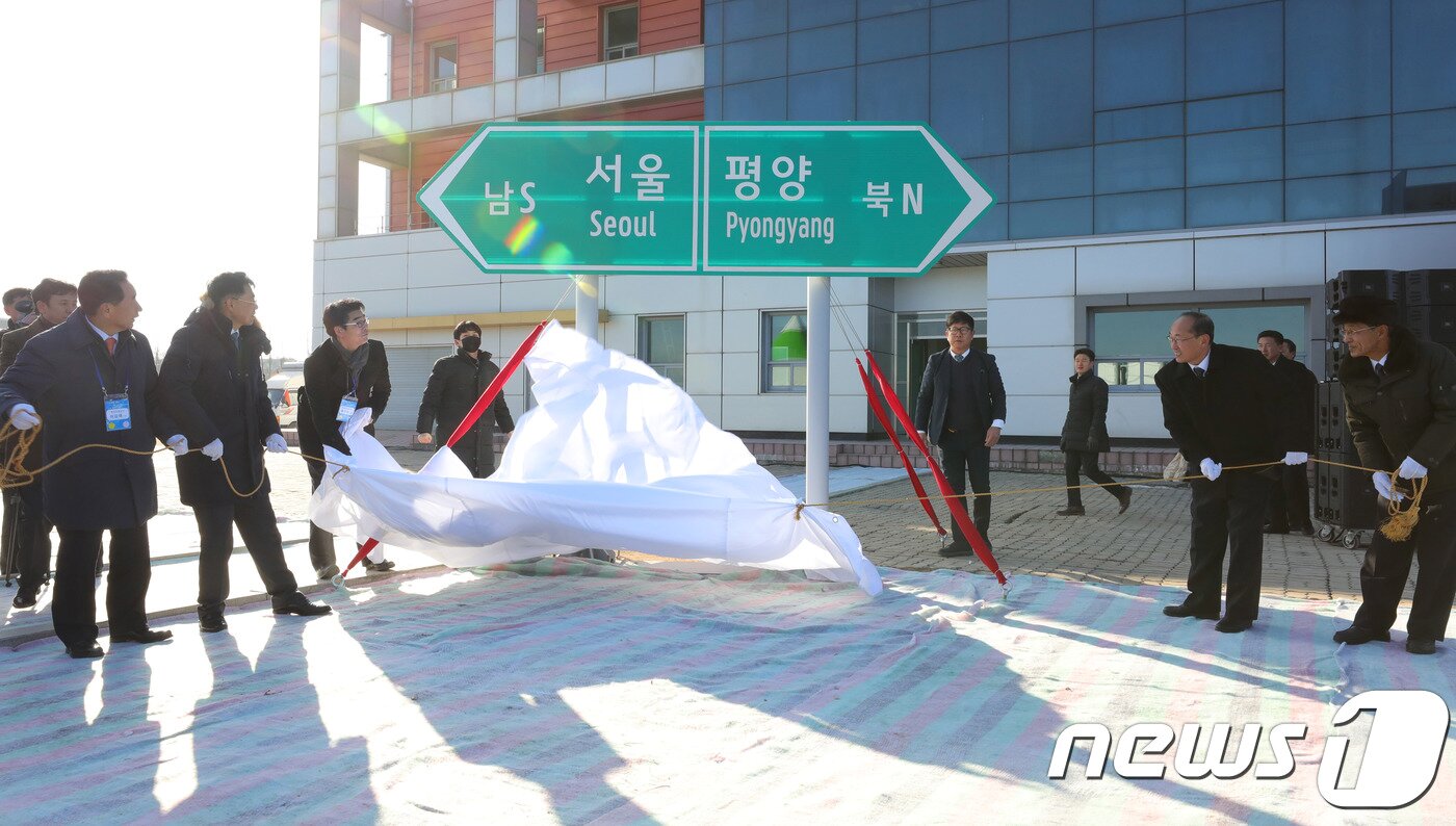 본문 이미지 - 26일 오전 북한 개성시 판문역에서 열린 남북 동서해선 철도, 도로 연결 및 현대화 착공식에 참석한 남북 인사들이 서울-평양 표지판 제막식을 하고 있다.2018.12.26/뉴스1 ⓒ News1 사진공동취재단