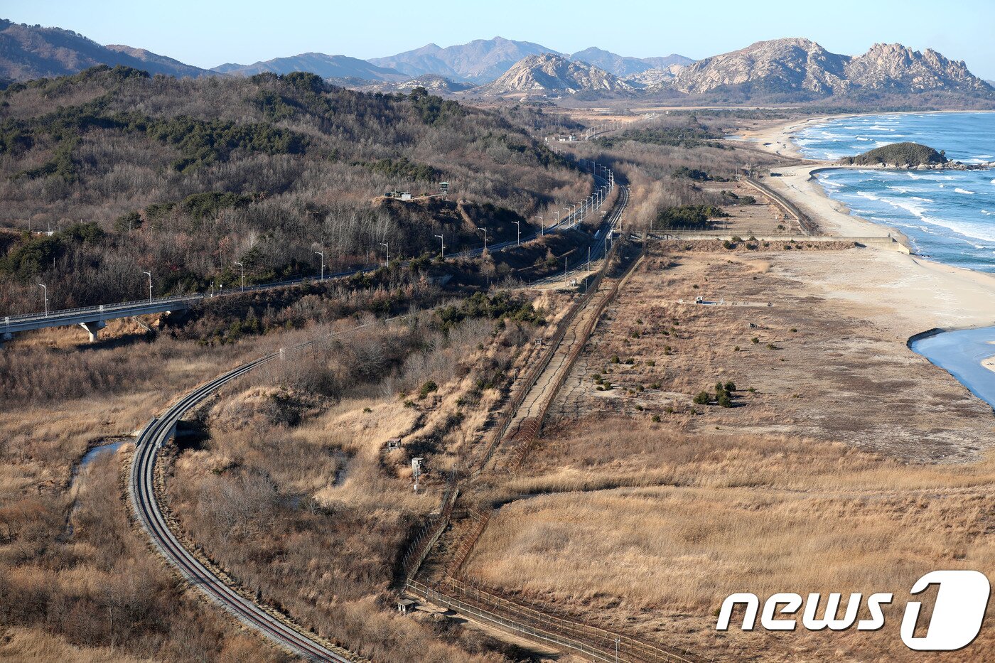 본문 이미지 - 28일 오후 강원도 고성 통일전망타워에서 바라본 일대 전경. 북으로 향하는 동해선 도로와 철도가 보이고 있다. 이날 개관한 전망타워는 현내면 명호리 산 31번지 일원에 지상 3층, 높이 34m, 건축연면적 1674.93㎡ 규모로 건립됐다. 1층에는 카페와 특산물 홍보·판매장, 2층에는 통일홍보관, 전망교육실, 라운지가 들어섰고 3층에는 전망대와 포토존이 조성됐다. 2018.12.28/뉴스1 ⓒ News1 고재교 기자