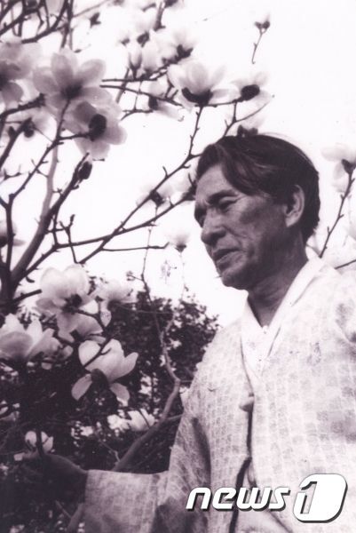 본문 이미지 - 비사벌초사에서 꽃을 보고 있는 신석정 시인(석정문학관 제공) ⓒ News1 김춘상 기자