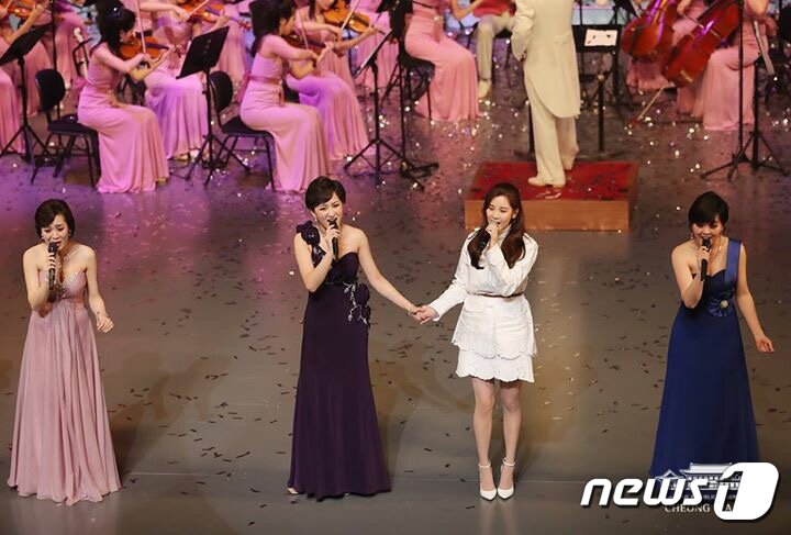 본문 이미지 - 서울 국립극장 해오름극장에서 열린 북한 예술단 공연에서 가수 서현이 북한 예술단 여자 가수들과 ‘우리의 소원’이라는 노래를 부르고 난 뒤 손잡고 있다. (청와대 페이스북)2018.2.11/뉴스1 ⓒ News1 이광호 기자