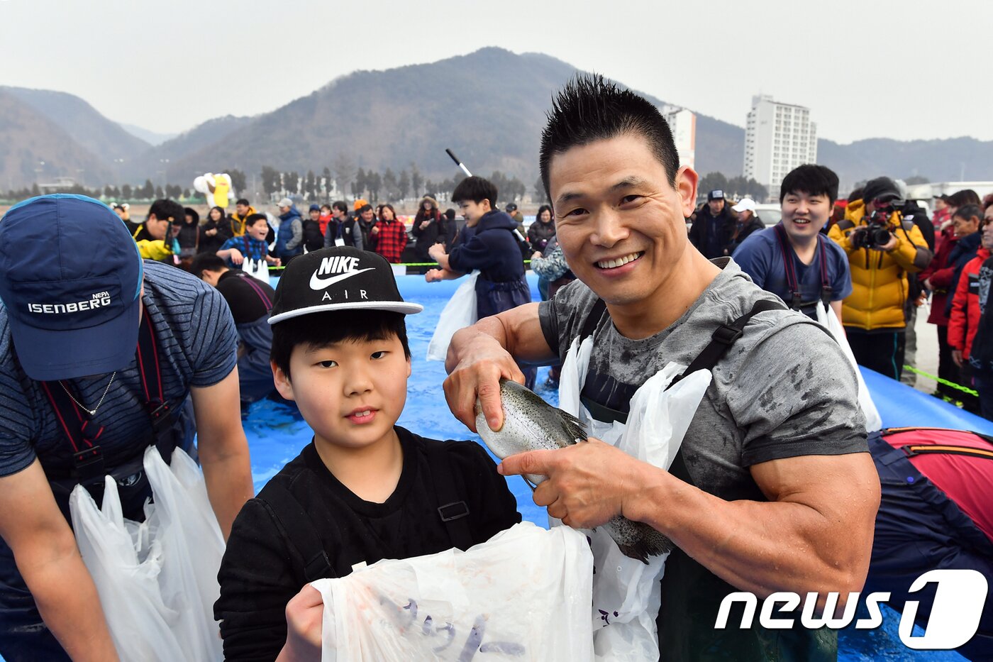 본문 이미지 - 25일 강원 정선군 조양강변에서 열린 정선고드름축제장 맨손 송업잡기 참가자들이 잡은 송어를 들고 기념촬영을 하고 있다. 2018.2.25/뉴스1 ⓒ News1 박하림 기자