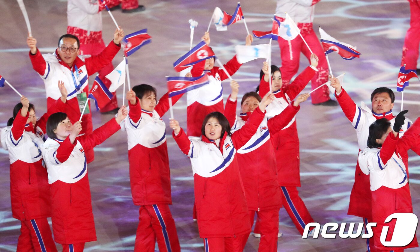 본문 이미지 - 2018년 2월 25일 강원도 평창올림픽스타디움 열린 2018 평창올림픽 폐회식에 참석한 북한 선수단이 한반도기와 인공기를 흔들며 입장하고 있다. 2018.2.25 ⓒ 뉴스1 허경 기자