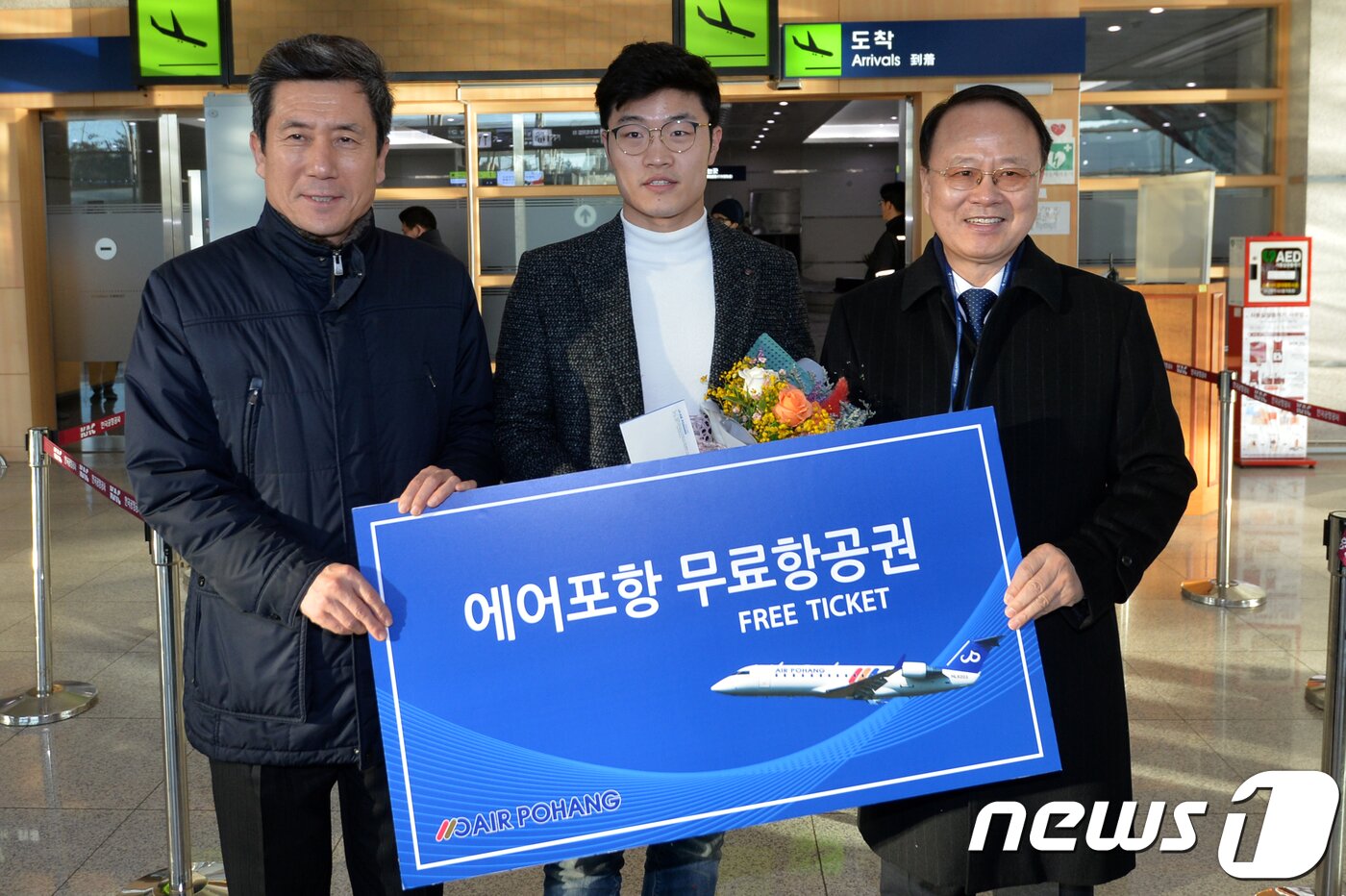본문 이미지 - 7일 오전 경북 포항공항에서 에어포항 첫 번째 고객인 하수원(28)씨가 이강덕 시장과 고덕천 에어포항사장(오른쪽)으로부터 무료 항공권을 받고 있다..2018.2.7/뉴스1 ⓒ News1 최창호 기자
