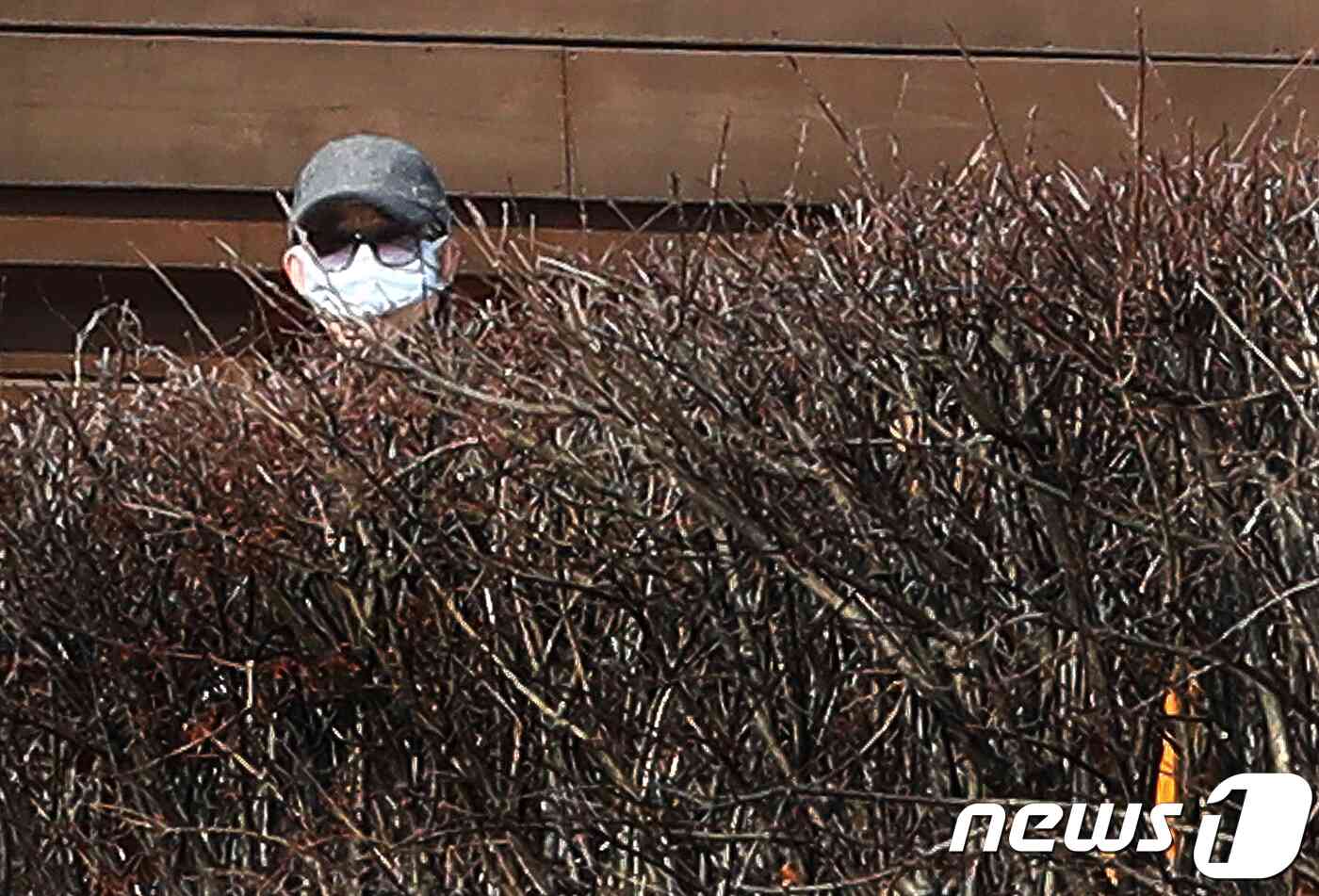 성추행 논란을 빚고 있는 고은 시인이 8일 오전 경기도 수원시 장안구 광교산 인근 고은 시인 자택 내 정원에서 회색모자와 선글라스, 마스크를 착용한 채 집 밖을 내다보고 있다. 2018.2.8/뉴스1 © News1 오장환 기자