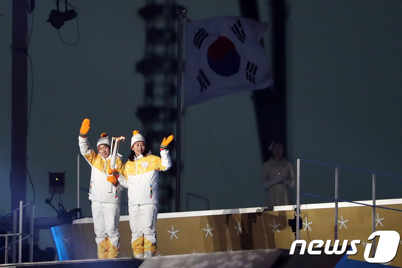 본문 이미지 - 2018 평창동계올림픽이 대단원의 막을 올린 9일 강원도 평창올림픽스타디움에서 열린 평창동계올림픽 개막식에서 성화봉송 주자로 나선 여자아이스하키 단일팀 박종아, 정수현이 관람객들을 향해 손을 흔들고 있다. 3만5000여명의 관람객과 전 세계 시청자 25억여명의 시선을 사로잡을 평창동계올림픽 개막식은 '행동하는 평화(Peace in motion)'를 주제로 2시간 동안 진행된다. 2018.2.9/뉴스1 ⓒ News1 허경 기자