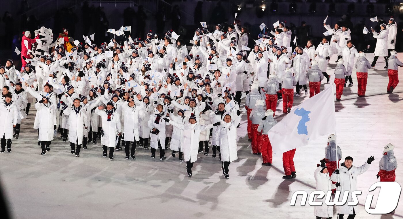 본문 이미지 - 9일 강원도 평창올림픽스타디움에서 열린 평창동계올림픽 개회식에서 남북한 선수단이 한반도기를 흔들며 입장하고 있다. ⓒ News1 유승관 기자