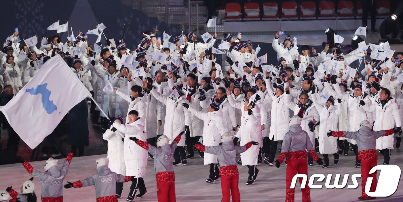본문 이미지 - 9일 강원도 평창올림픽스타디움에서 열린 평창동계올림픽 개막식에서 남과 북 선수들이 한반도기를 흔들며 공동 입장하고 있다. 2018.2.9/뉴스1 ⓒ News1 허경 기자