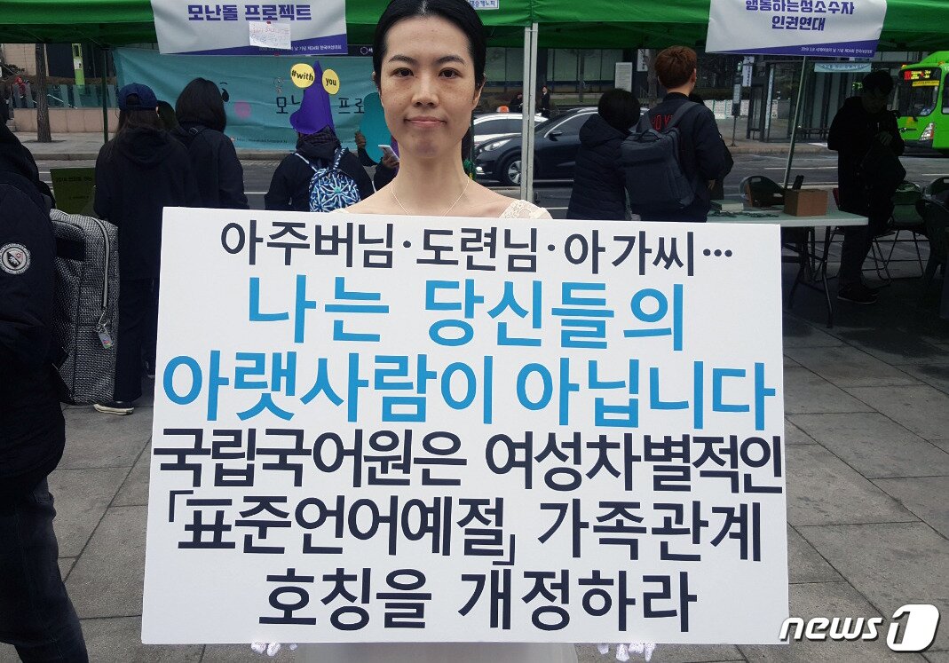 본문 이미지 - 4일 결혼식 피로연에서 입었던 하얀 드레스를 입고 서울 종로구 광화문 광장에 선 배윤민정씨(33·여)가 '아주버님·도련님·아가씨…나는 당신들의 아랫사림이 아닙니다'라는 피켓과 함께 국립국어원에 여성차별적인 표준어를 개정하라고 촉구하고 있다. 2018.3.4/뉴스1ⓒ News1 최동현 기자